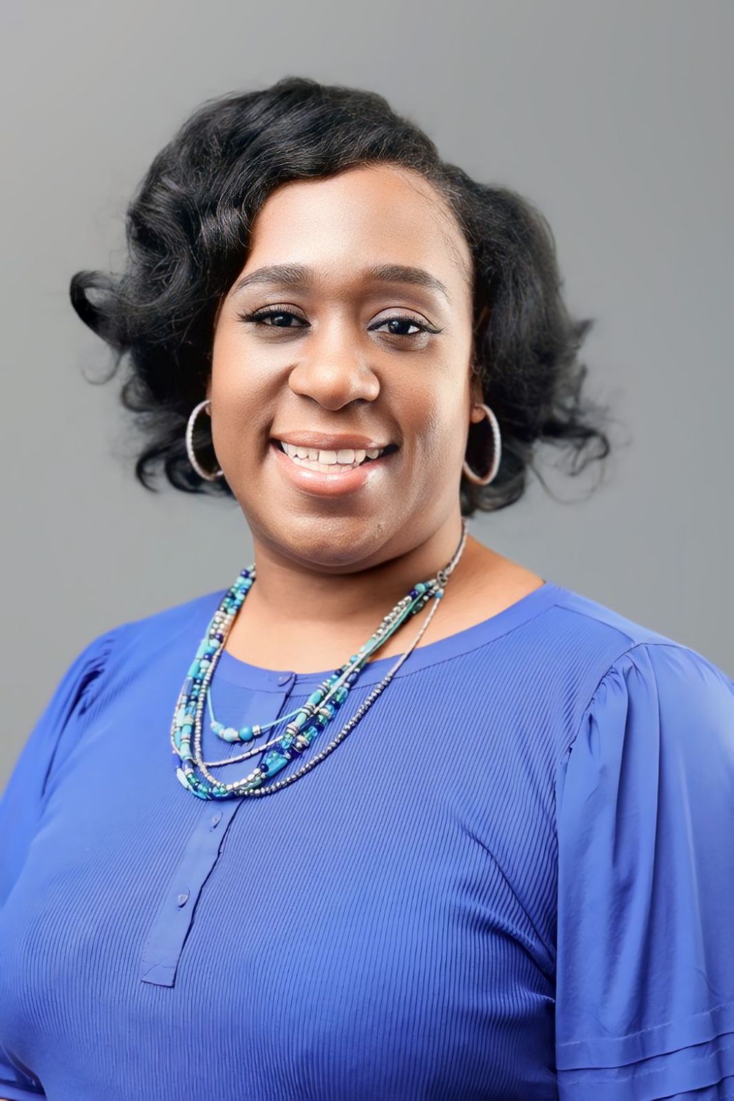 Picture of Angeline Walker wearing a blue shirt and a cyan necklace.